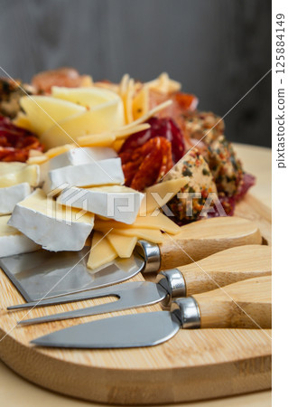 Wooden charcuterie cheese board holiday present idea. Snack starter plate for dinner with wine. Italian appetizers or antipasto set with gourmet food. Buffet party Wooden charcuterie cheese board holiday present idea. Snack starter plate for dinner with wine. Italian appetizers or antipasto set with gourmet food. Buffet party 125884149