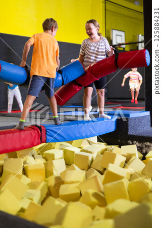 Tween girl having fun on battle beam with friend 125884231