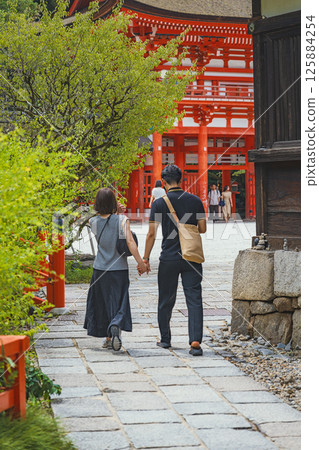 A couple walking along the approach to Shimogamo Shrine (Kamo Mioya Shrine) in Kyoto 125884254