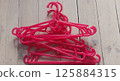 pink plastic hangers flat lay on rustic white wooden background  125884315