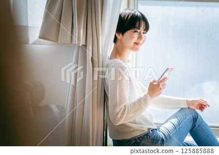 A woman who operates a smartphone in the room A woman who operates a smartphone in the room 125885888