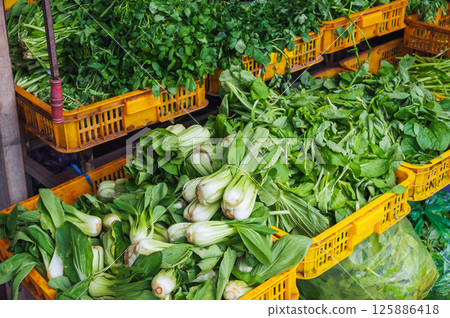 assortment of fresh herbs and salad greens at a farmer's vegetable market in Asia 125886418