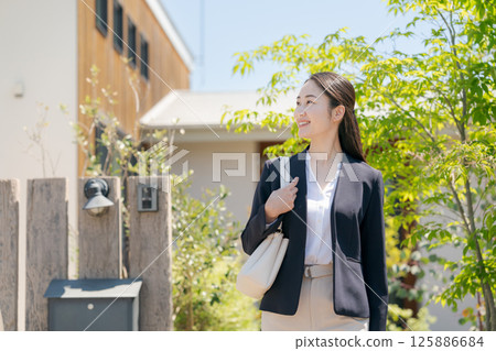 A woman in a suit leaving the entrance A woman in a suit leaving the entrance 125886684