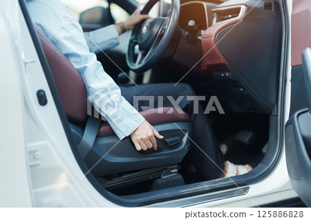 Business woman hand adjust car seat before drive on the road. Ergonomic, health care and safety transportation concept Business woman hand adjust car seat before drive on the road. Ergonomic, health care and safety transportation concept 125886828