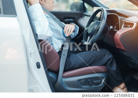Business woman driver hand fastening seat belt during sitting inside a car and driving in the road. safety, trip, journey and transport concept Business woman driver hand fastening seat belt during sitting inside a car and driving in the road. safety, trip, journey and transport concept 125886831