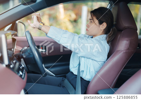 woman feeling sleepy and yawn during drive car long time. Asian girl tired and fatigue having headache after driving car in traffic jam. Sleep, stretching and safety concept 125886855