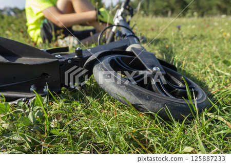 Close-Up of a Scooter in a Sunny Outdoor Setting on Grass 125887233