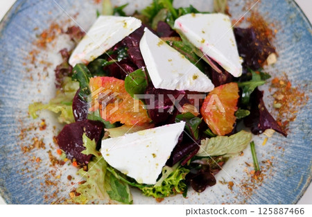 beetroot salad with blue cheese, arugula and walnut in a white plate on gray background, top view beetroot salad with blue cheese, arugula and walnut in a white plate on gray background, top view 125887466