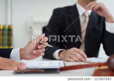Client Consultation and Legal Advice. A lawyer providing valuable advice to a client during a professional meeting. Client Consultation and Legal Advice. A lawyer providing valuable advice to a client during a professional meeting. 125887663