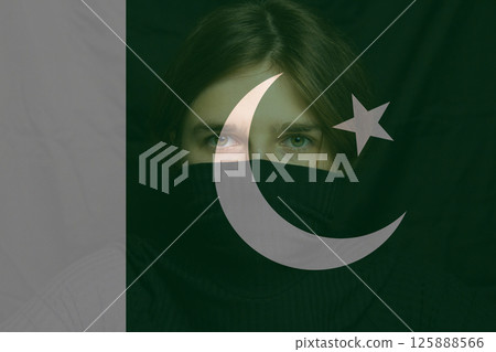 Woman, a refugee from war, holds a Pakistani flag. A victim of conflict, among many women seeking refuge. War between India and Pakistan Woman, a refugee from war, holds a Pakistani flag. A victim of conflict, among many women seeking refuge. War between India and Pakistan 125888566