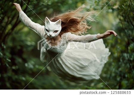 A whimsical fairy tale scene with a woman in a flowing white dress and cat mask, set in a forest. The woman, portrayed in a dreamy, ethereal style, appears to be flying or floating amidst the trees 125888633