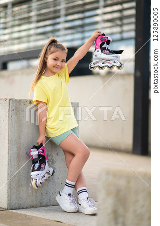 Active kid skating outdoors enjoying playtime mastering roller-blades Active kid skating outdoors enjoying playtime mastering roller-blades 125890005