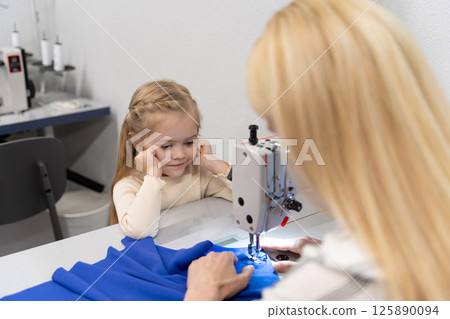 Cute little girl spending time with her mom in a designers studio Cute little girl spending time with her mom in a designers studio 125890094