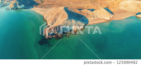 Panoramic view from above of rocky seashore. Seascape with rocky beach and green water. Cabo de Gata-Nijar reserve. Almeria, Spain 125890482