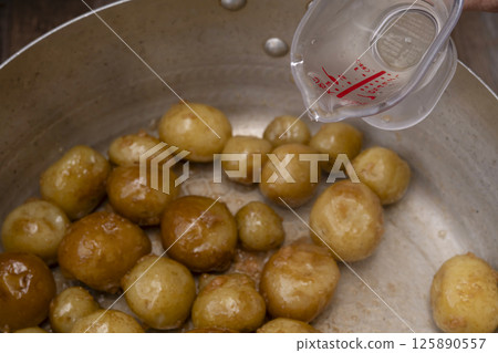 The process of making boiled small potatoes with skin 125890557