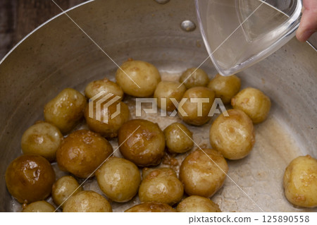 The process of making boiled small potatoes with skin 125890558