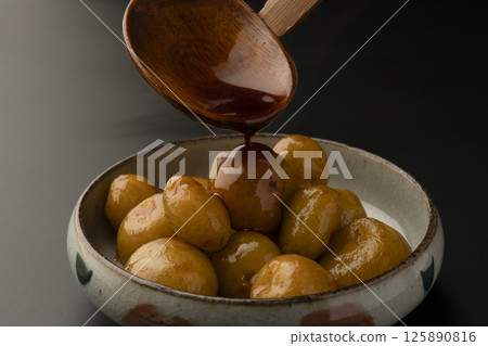 Picking up boiled small potatoes with their skins on using chopsticks Picking up boiled small potatoes with their skins on using chopsticks 125890816