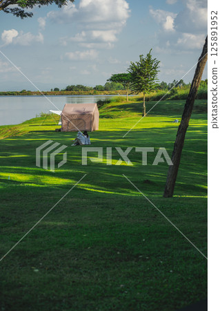 travel and people activity concept with camping on grass  with mountain and lake on foreground 125891952