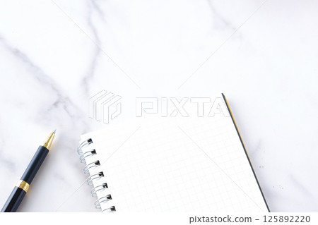 An image of doing desk work with a ring-type notepad and pen An image of doing desk work with a ring-type notepad and pen 125892220