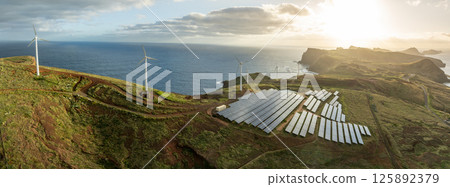 Solar energy panels photovoltaic cell and wind power plants on the seashore landscape for production of renewable green energy 125892379