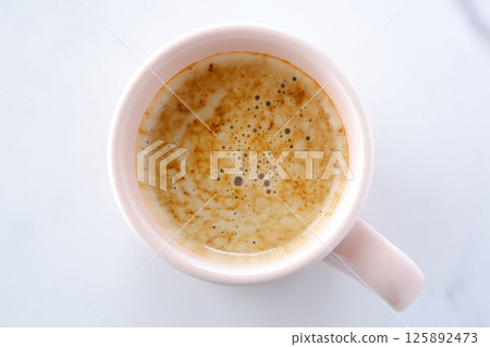 Image of a person relaxing while drinking a cafe latte, a mixture of espresso and milk Image of a person relaxing while drinking a cafe latte, a mixture of espresso and milk 125892473