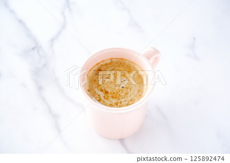 Image of a person relaxing while drinking a cafe latte, a mixture of espresso and milk Image of a person relaxing while drinking a cafe latte, a mixture of espresso and milk 125892474