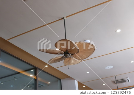 Ceiling fan is mounted on the ceiling indoors.  125892476