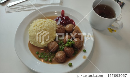 Swedish meatballs with mashed potatoes, gravy, peas, and lingonberry jam at ikea restaurant 125893067