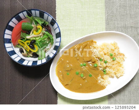 Chicken curry with carrot rice and black bean salad 125893204
