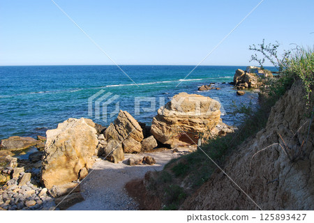 Beautiful landscape of the Black Sea. The natural coastline of the Odessa Bay consists of shell rock and clay against which the sea waves break. 125893427
