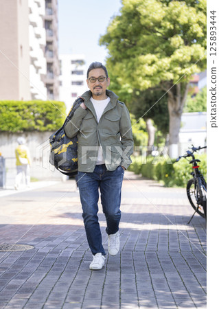 一名 50 多歲的男子在鎮上散步 一名 50 多歲的男子在鎮上散步 125893444