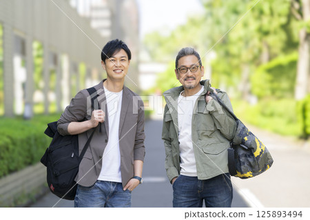 Men in their 40s and 50s smiling at the camera Men in their 40s and 50s smiling at the camera 125893494