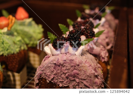 round croissant round golden brown pastry filled with custard and topped with blueberries, strawberries. long white cream and sugar covered dessert 125894042