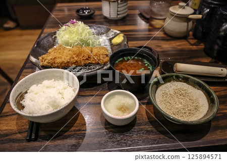Japanese Meal Featuring Tonkatsu and Accompaniments on Wooden Table 125894571