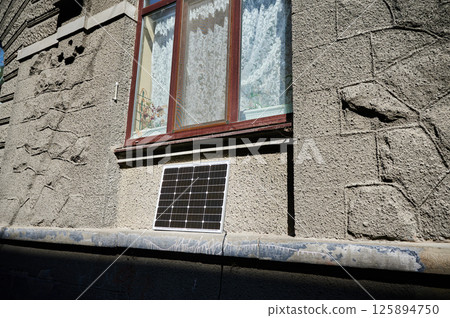 Photovoltaic solar panel in front of historical building. Concept of integration of sustainable renewable energy sources into old architecture. 125894750