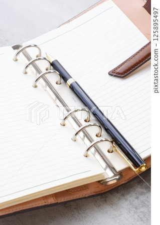 Image of a ring-type system organizer open while doing desk work Image of a ring-type system organizer open while doing desk work 125895497