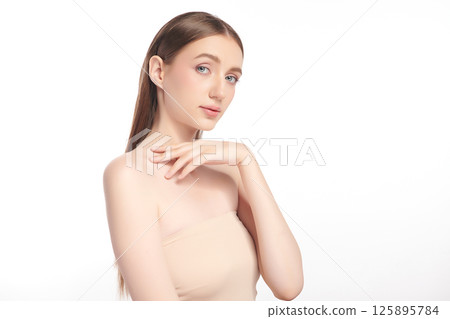 A beautiful young woman with clean, fresh skin against a white background. Skincare, facial treatment, cosmetology, beauty, and spa. An elegant portrait of an woman. 125895784