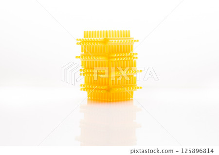 The children's construction set is presented in the form of yellow blocks arranged on a bright background. Playing with such details arouses interest in modeling. 125896814