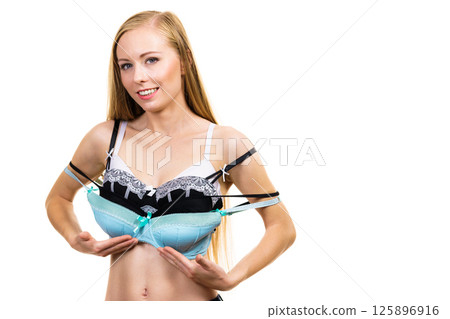 Female holds bras. Bra fitting 125896916