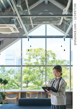 一名女士正在檢查空調機組 一名女士正在檢查空調機組 125897140