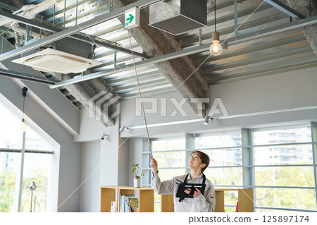 一名女士正在檢查疏散指示燈的運作情況 125897174