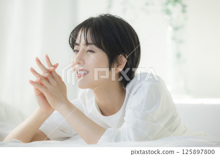 A woman relaxing in bed 125897800