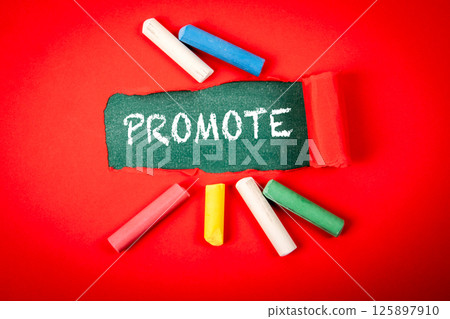 Promote Concept with Chalk on Chalkboard and Colorful Crayons 125897910