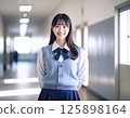 一名身穿校服、微笑的女學生站在學校走廊裡 125898164