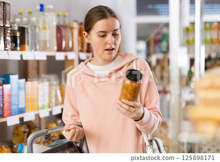 Woman choosing lentils in the store Woman choosing lentils in the store 125898171