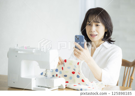 Woman doing dressmaking at home 125898185