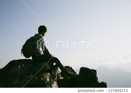 Man traveler with camera backpack hiking outdoor travel lifestyle and adventure concept. cap backpack and join of tourist for green mountain tour, beauty of nature and expansive sky people of tourism Man traveler with camera backpack hiking outdoor travel lifestyle and adventure concept. cap backpack and join of tourist for green mountain tour, beauty of nature and expansive sky people of tourism 125898213
