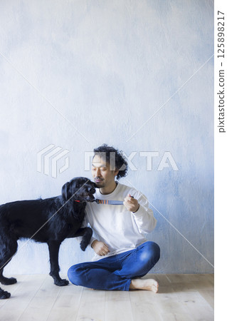 Man relaxing with his dog 125898217