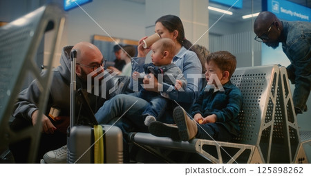 Boarding Lounge of Airline Hub: Woman with Two Little Children Waiting for Airplane Flight Boarding Lounge of Airline Hub: Woman with Two Little Children Waiting for Airplane Flight 125898262