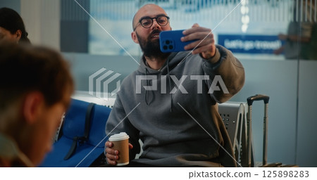 Airport Terminal: Popular Travel Blogger Filming Video Content Using Smartphone 125898283